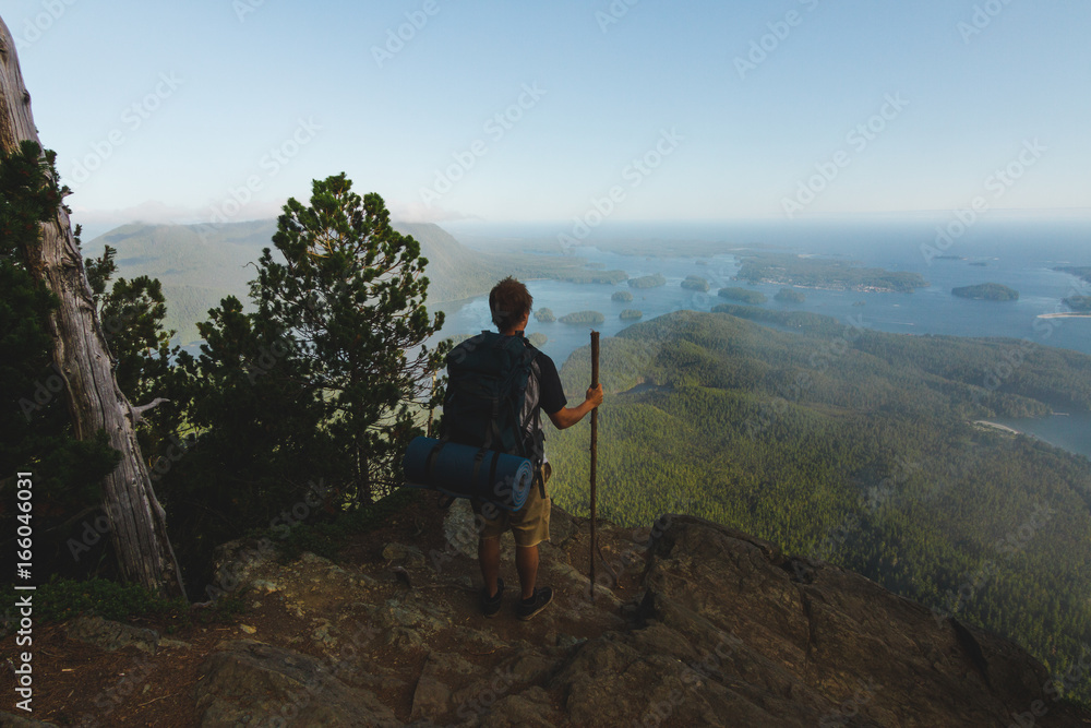 Fototapeta premium Man standing on the cliff with view on ocean and islands