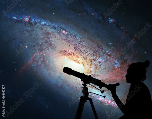 Girl looking at the stars with telescope. Spiral Galaxy M106, in the constellation Canes Venatici.  photo