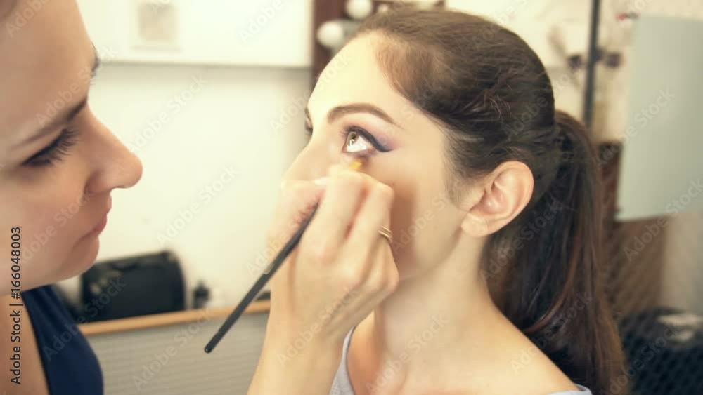 Young beautiful woman applying make-up by make-up artist Young beautiful woman applying make-up by make-up artist