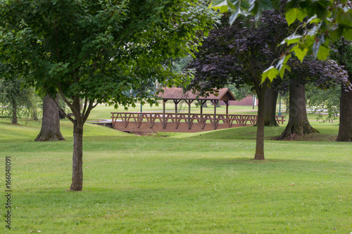 A walk bridge at a park on a beautiful summer day makes a pretty scene