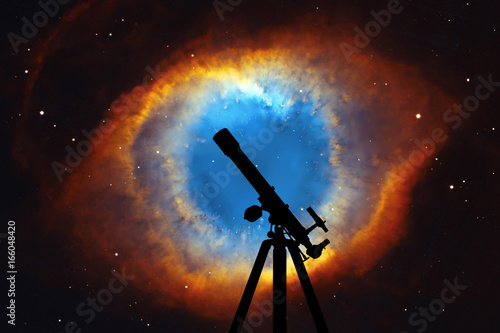 Space background with silhouette of telescope. The Helix Nebula or NGC 7293 in the constellation Aquarius. 