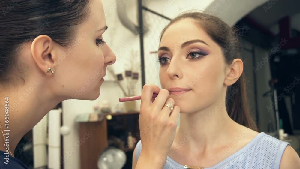 Young beautiful woman applying make-up by make-up artist Young beautiful woman applying make-up by make-up artist
