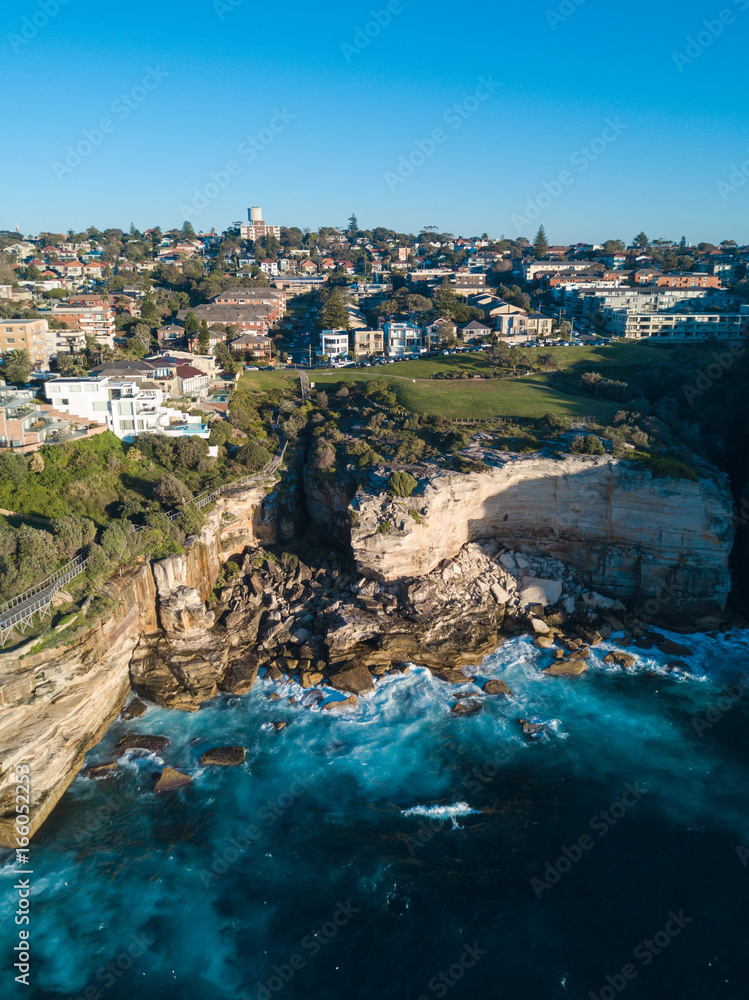 Aerial view of rock cliff and residential area around it.