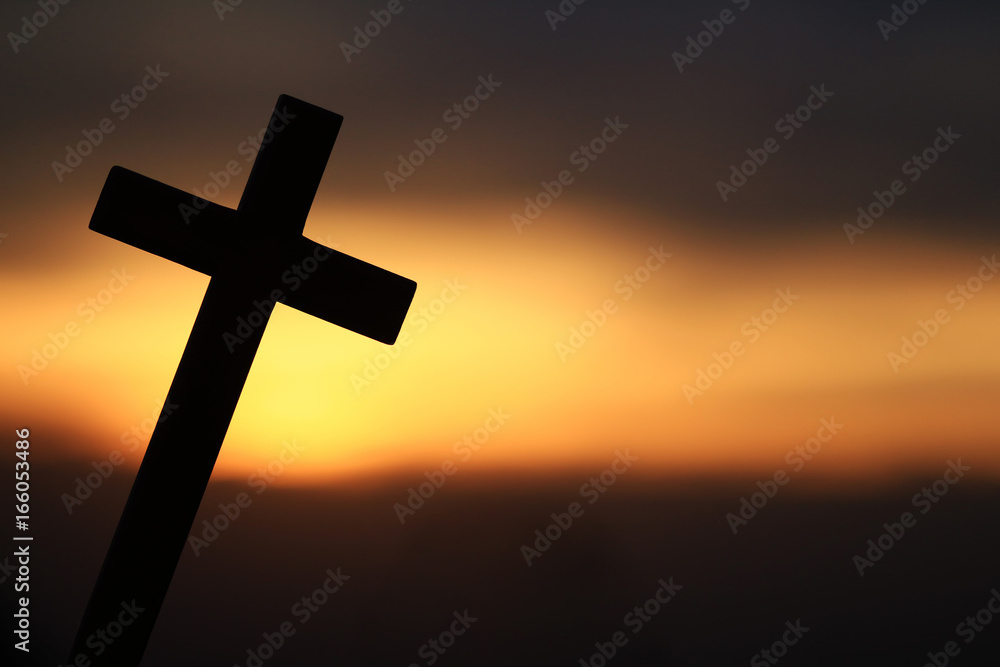Silhouette of a wooden cross in a beautiful sunset