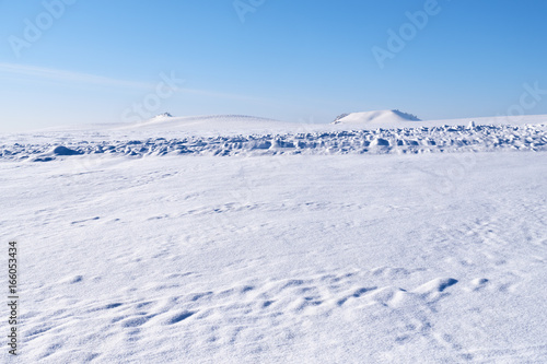 Altai plain winter landscape with snow field under blue sky