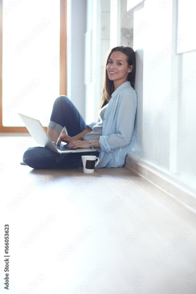 Young beautiful woman at home sitting on the floor with laptop. Young beautiful woman. Young beautiful woman at home sitting on the floor with laptop. Young beautiful woman.