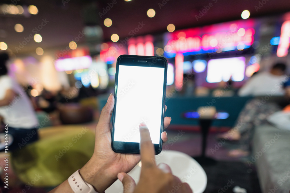 Hands holding blank white screen smart phone in front of the movie theatre, Hands holding smart phone to use for online booking ticket. Hands holding blank white screen smart phone in front of the movie theatre, Hands holding smart phone to use for online booking ticket.