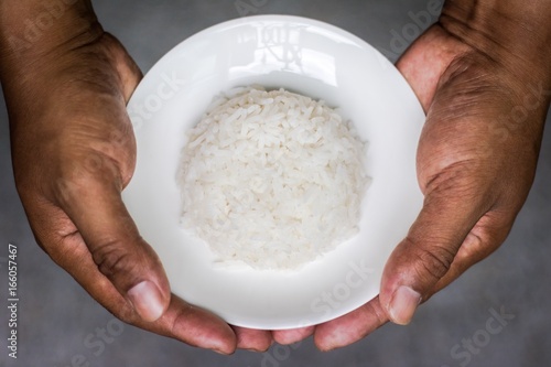 Rice and dish on both hands.