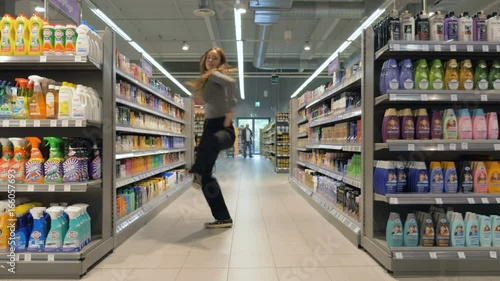 Young woman dancing through grocery store aisles. 