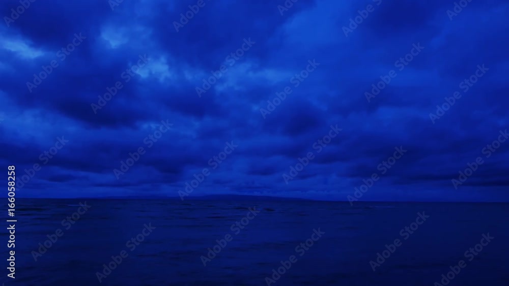 A very blue, cloudy sunrise video from Dumaguete City shores. Video stars dark, and lightens up as the sun rises. Presented as hyperlapse (panning camera) A very blue, cloudy sunrise video from Dumaguete City shores. Video stars dark, and lightens up as the sun rises. Presented as hyperlapse (panning camera)