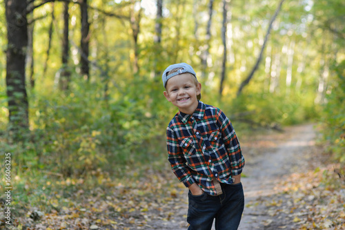 happy boy in autumn forest