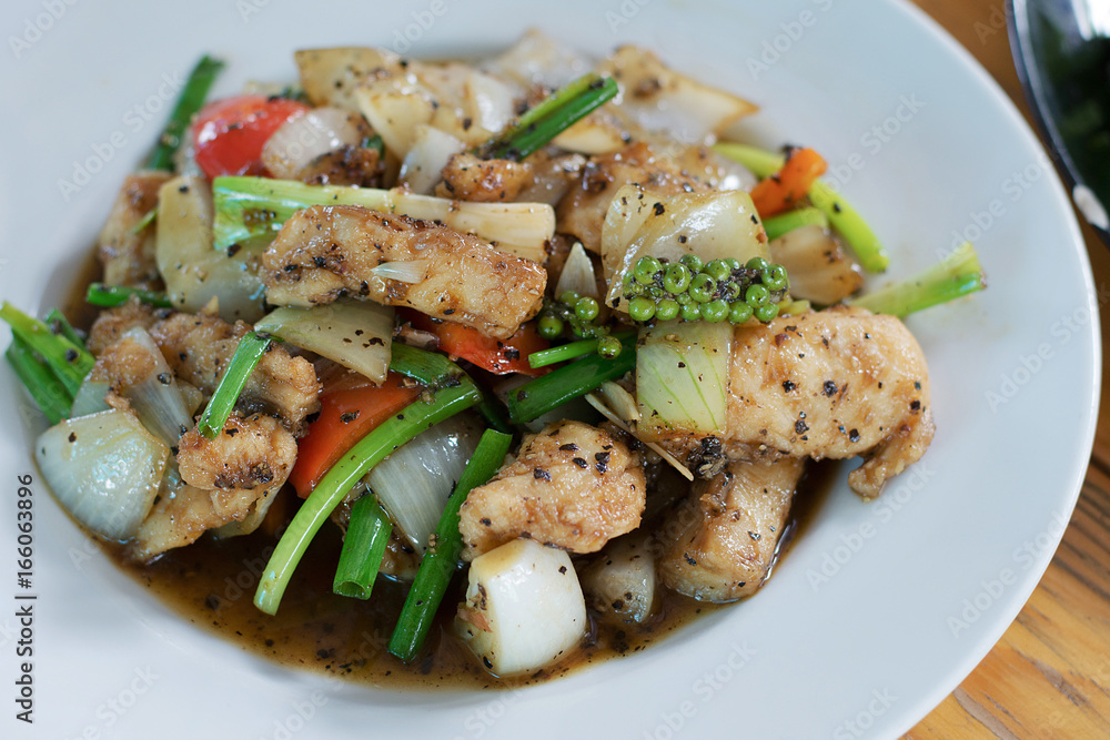 Close-up stir fried fish with black pepper in white plate Close-up stir fried fish with black pepper in white plate