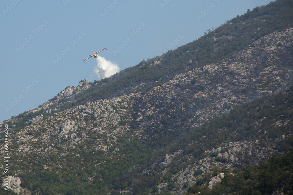 Airplane extinguishing the huge forest fires on the mountains close to Herceg Novi and the bay of Kotor in Montenegro
