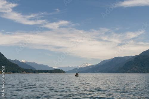 Lone kayaker on water with mountains in the background © Martin Hossa
