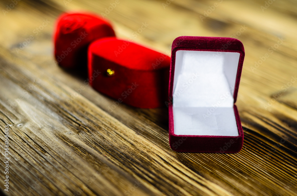 Different red jewelry boxes on wooden table Different red jewelry boxes on wooden table