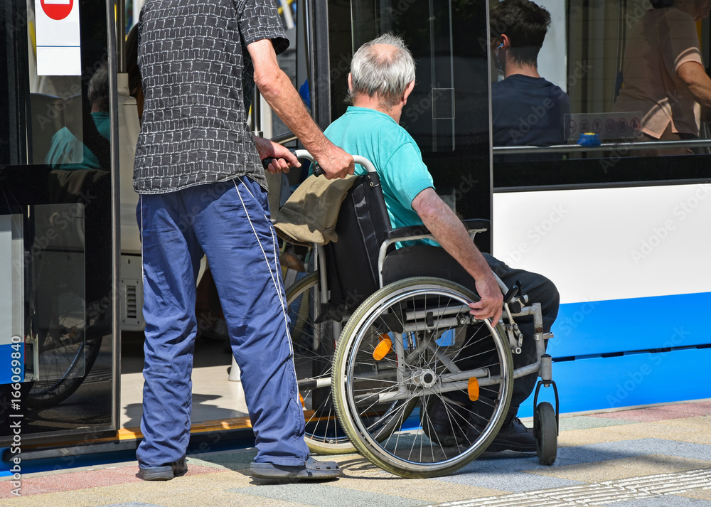 Obraz premium Man in wheelchair get in to the tram