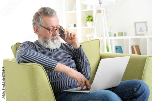 Handsome elderly man sittin...