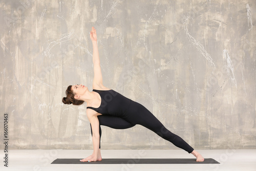 Young woman practicing yoga...