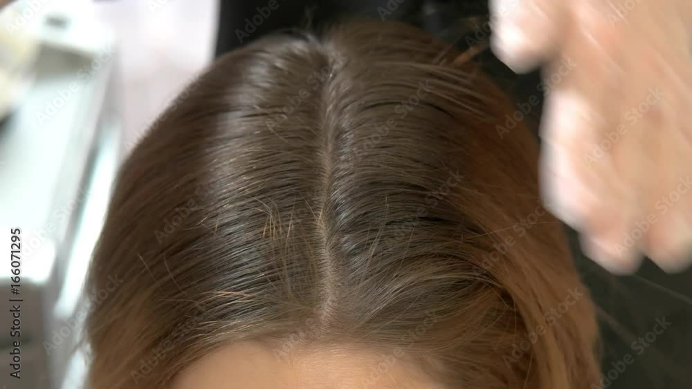 Hands of beautician brushing hair. Brown female hair and comb. Hands of beautician brushing hair. Brown female hair and comb.