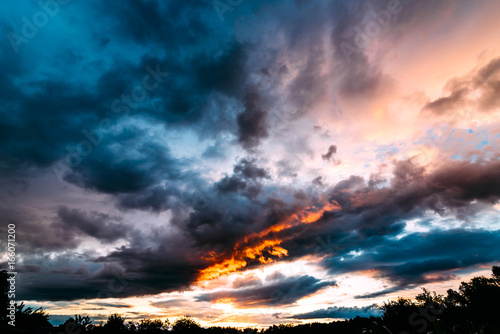 Dramatic gray, blue and orange sunset on beautiful sky, free space. Sky background on sunset with clouds