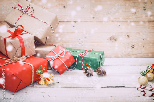 Christmas background - Christmas present gifts box and snow on wooden background. vintage color tone © jakkapan