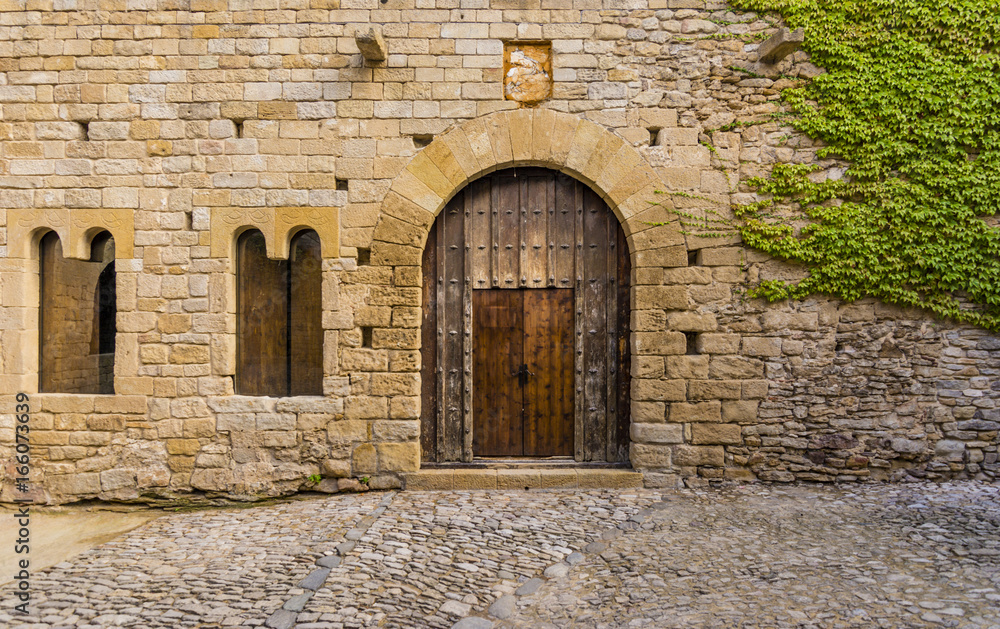 Ancient wooden door of a castle in Peratallada, Spain Ancient wooden door of a castle in Peratallada, Spain