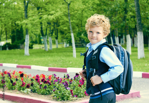 Little schoolboy with a backpack go to school. Outdoor. Education, back to school concept. Side view.