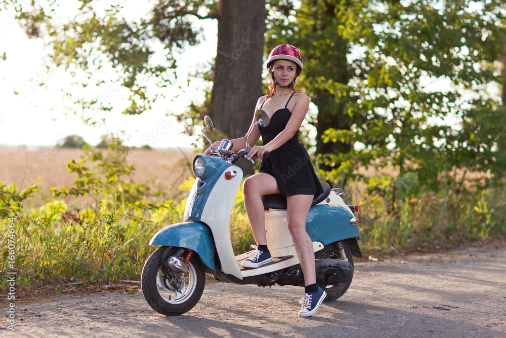 Obraz premium A girl with a scooter on a country road