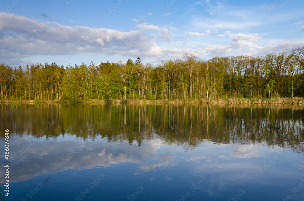 Sunset in the countryside with lake, forest an forest mirroring