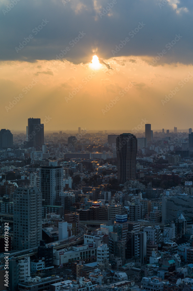 雲の切れ間から陽光がさす東京