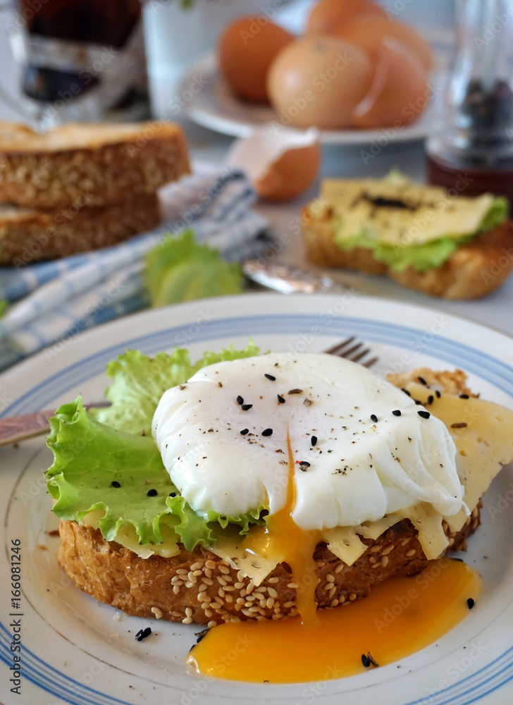 Egg poached on toast with cheese and lettuce leaves Egg poached on toast with cheese and lettuce leaves