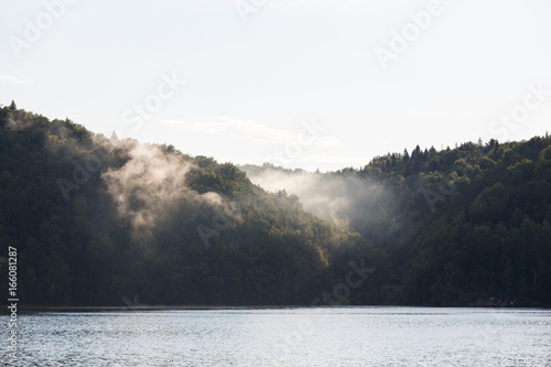 Fog in the mountains at sunset light of the lake. Bay after rain, beautiful landscape