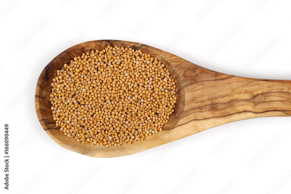 Yellow mustard seeds in wooden spoon isolated on white background, top view Yellow mustard seeds in wooden spoon isolated on white background, top view
