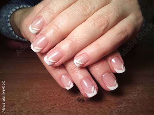 The manicurist excellently made her work a beautiful manicure with a polish gel on her hands and the client is happy