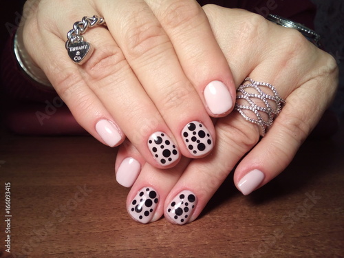 The manicurist excellently made her work a beautiful manicure with a polish gel on her hands and the client is happy