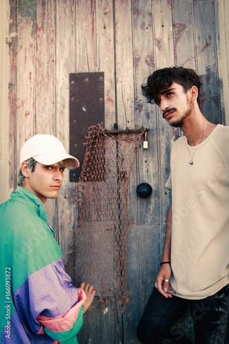 Two handsome young men next to an old door © juanorihuela