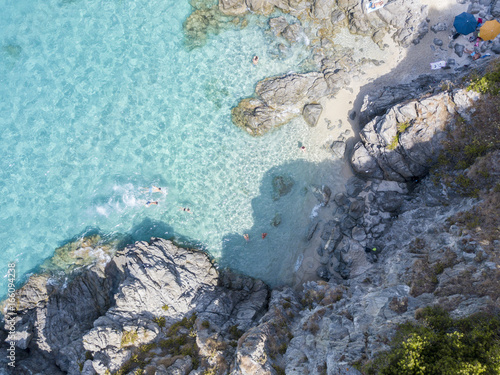 Vista aerea di scogli sul mare. Panoramica del fondo marino visto dall   alto  acqua trasparente. Nuotatori  bagnanti che galleggiano sull   acqua