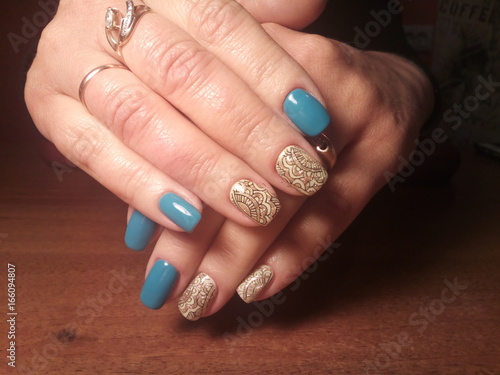 The manicurist excellently made her work a beautiful manicure with a polish gel on her hands and the client is happy