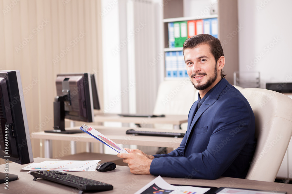 Fototapeta premium Portrait of Businessman in suit working in his office. Business and corporate. Image of young succesful entrepreneur at his work place.