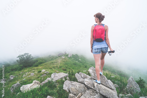 girl traveler with a camera in mountains