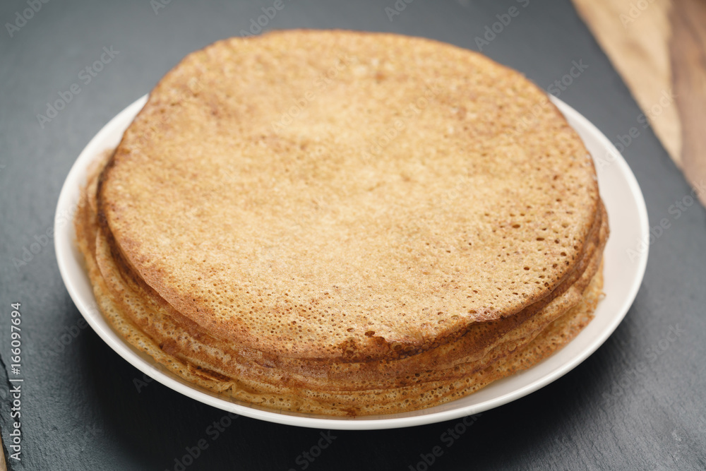 homemade blini stack on plate on slate board homemade blini stack on plate on slate board