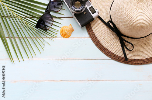 welcome summer with hats,Sunscreen,coconut leaves and Shell on the blue table background