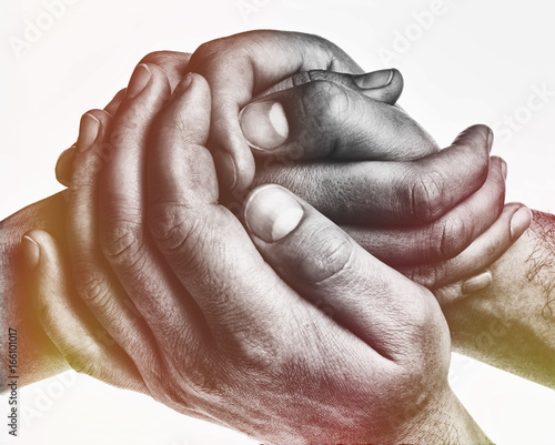 Men's hands hold the female palm on light, toned background. That could mean help, guardianship, protection, love, care etc. photo