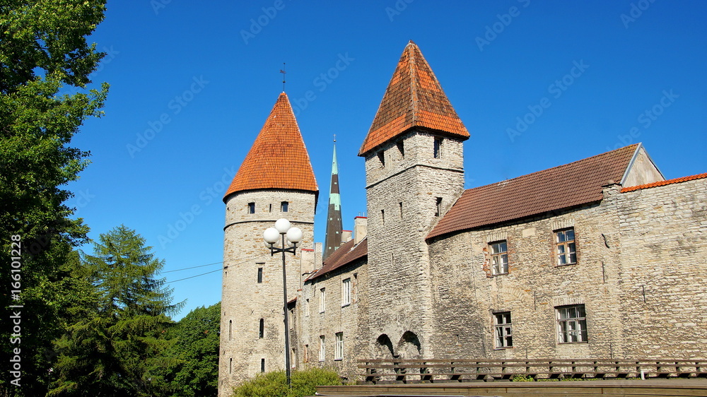 alte Stadtmauer von Tallinn mit zwei Wehrtürmen vor strahlend blauem Himmel
