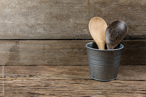 wooden kitchen set skimmer, spade of frying pan in metal box on wooden