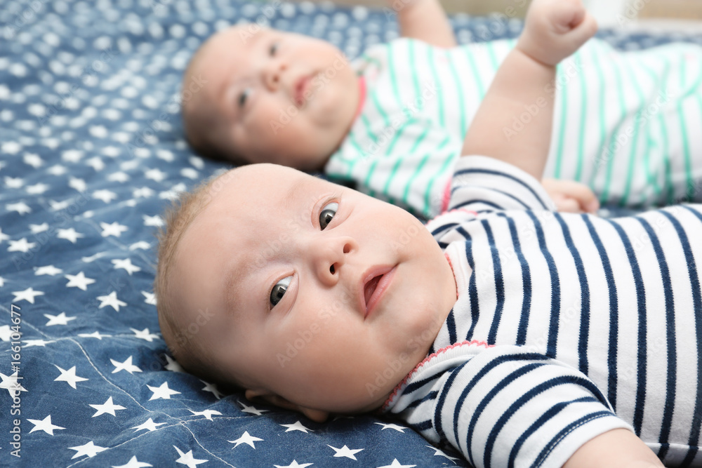 Beautiful baby twins lying together on bed Beautiful baby twins lying together on bed