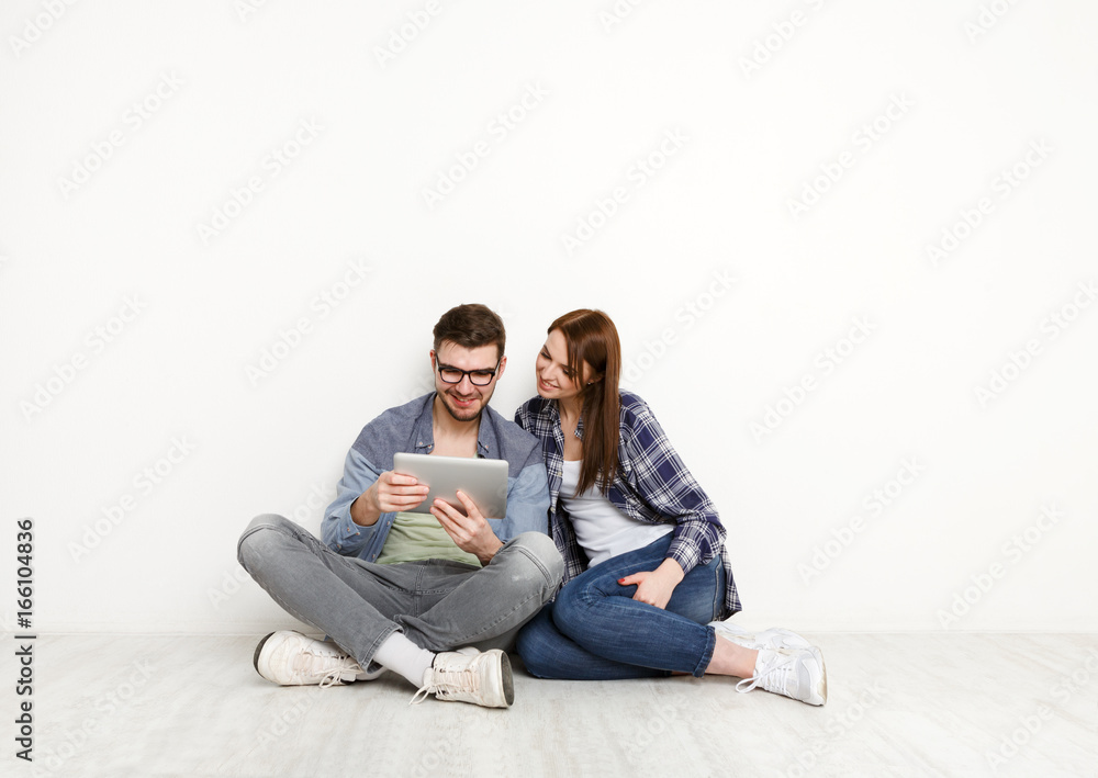 Casual couple working with tablet, studio shot