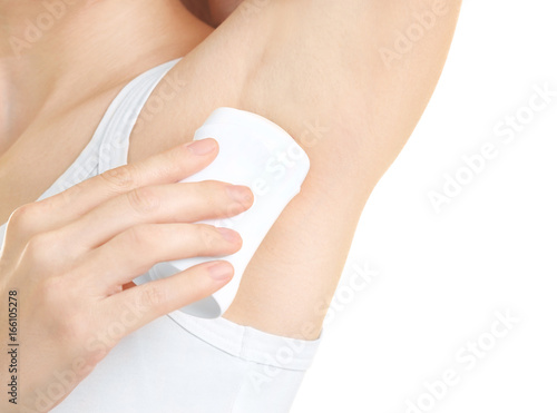 Beautiful young woman using deodorant on white background, closeup