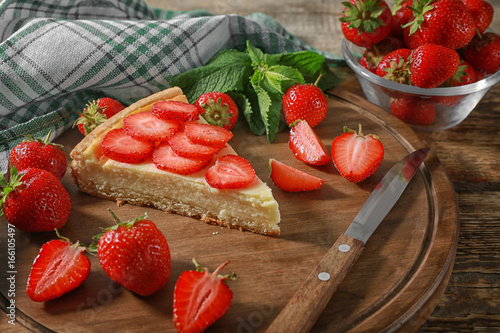 Piece of tasty strawberry cake on wooden board