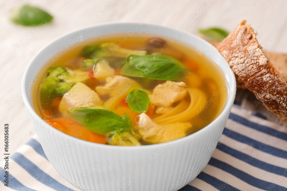 Bowl with delicious turkey soup and bread on table Bowl with delicious turkey soup and bread on table